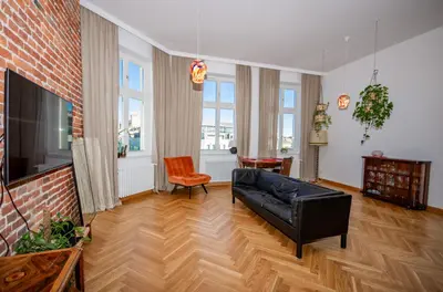 a living room with a couch and a brick wall at InPoint Royal Wawel View & Old Town Apartment Self Check-in in Kraków
