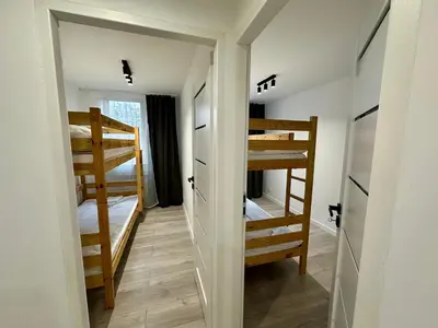 a room with two bunk beds and a hallway at Apartament Powstańców 17 in Oświęcim