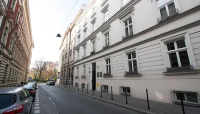 a city street with white buildings and cars parked on the street at Barbakan Loft Old Town in Kraków