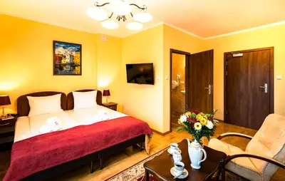 a hotel room with a bed and a living room at Hotel Kasztelan in Dobczyce