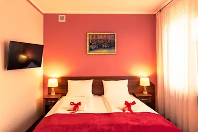 a red bedroom with a bed with two red bows on it at Hotel Kasztelan in Dobczyce