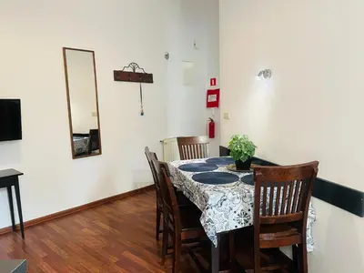 a dining room with a table with chairs and a mirror at Old Town Apartments 2 in Kraków