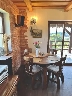 a dining room with a wooden table and chairs at Kefasówka in Zawoja