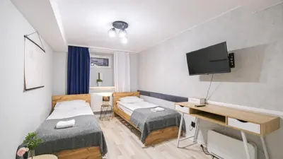 a small room with two beds and a television at Przytulny Zakątek Wawel in Kraków