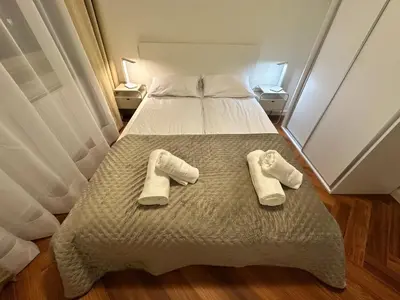 a bed with two pairs of white slippers on it at Bajeczny Apartament 88 - 20 min to Cracow Airport - beside the Vistula River in Kraków