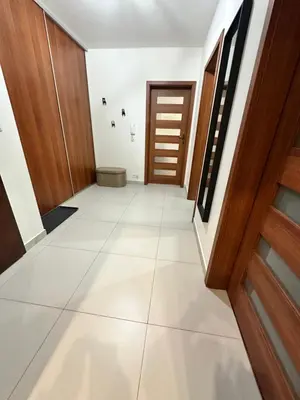 a corridor of a house with white floors and wooden doors at Bajeczny Apartament 88 - 20 min to Cracow Airport - beside the Vistula River in Kraków