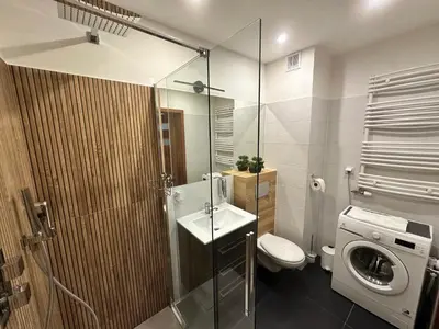 a bathroom with a toilet and a sink and a washing machine at Bajeczny Apartament 88 - 20 min to Cracow Airport - beside the Vistula River in Kraków