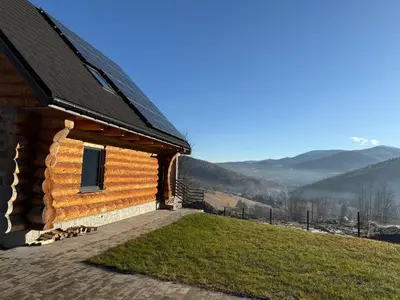 a log cabin with a view of the mountains at Domek z Bali in Zawoja