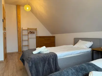 a bedroom with two beds and a wooden floor at Domek z Bali in Zawoja
