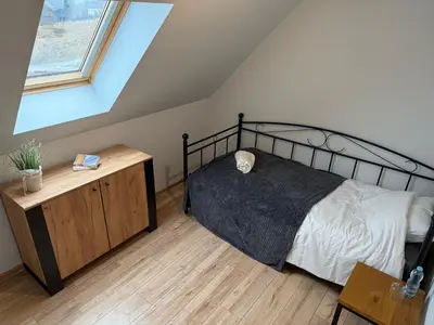 a bedroom with a black bed and a window at Domek z Bali in Zawoja