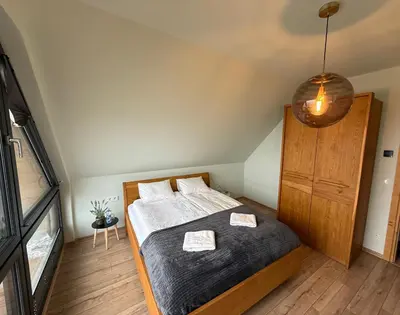 a bedroom with a bed and a wooden cabinet at Domek z Bali in Zawoja