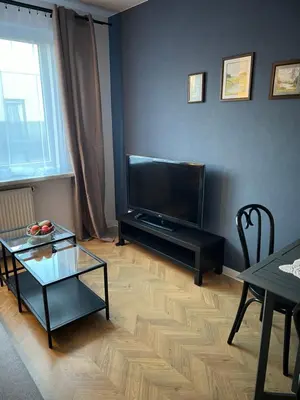a living room with a flat screen tv and a table at Raciborska Loft in Kraków