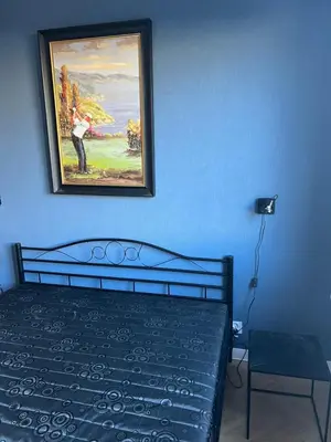 a bedroom with a painting on the wall and a bed at Raciborska Loft in Kraków