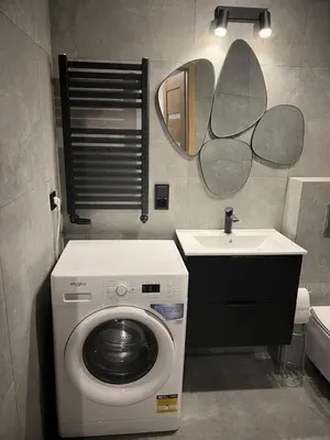 a bathroom with a washing machine and a sink at Raciborska Loft in Kraków