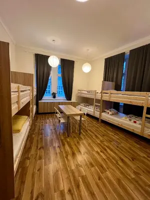 a room with two bunk beds and a table at Fox hostel in Kraków