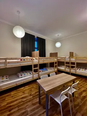 a classroom with bunk beds and a table and chairs at Fox hostel in Kraków