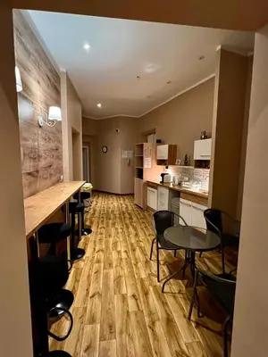 a room with a kitchen with tables and chairs at Fox hostel in Kraków