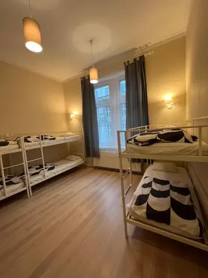 a room with three bunk beds and a window at Fox hostel in Kraków