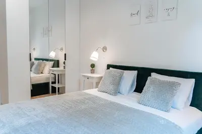 a bedroom with a large bed with blue and white pillows at K&M Apartments Tauron Arena in Kraków
