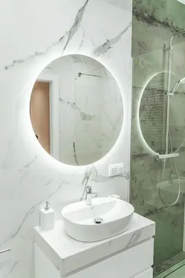 a white bathroom with a sink and a mirror at K&M Apartments Tauron Arena in Kraków