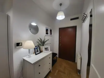 a room with a dresser with a lamp and a door at Kochanowskiego 12 in Kraków