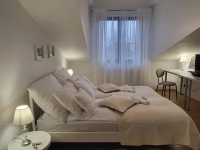 a white bed with white sheets and pillows in a bedroom at Kochanowskiego 12 in Kraków