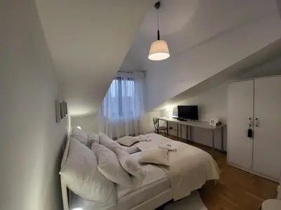 a white bedroom with a large bed in a room at Kochanowskiego 12 in Kraków