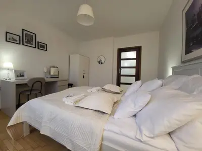 a white bed with white pillows on top of it at Kochanowskiego 12 in Kraków