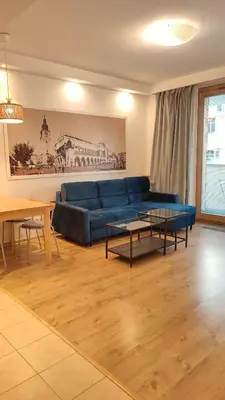 a living room with a blue couch and a table at Art Zwierzyniecka in Kraków