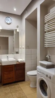 a bathroom with a washing machine and a sink at Art Zwierzyniecka in Kraków