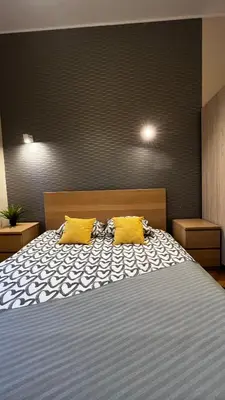 a bedroom with a bed with two yellow pillows at Studio in City Center in Kraków