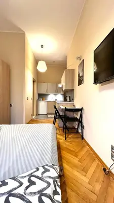 a room with a bed and a kitchen with a table at Studio in City Center in Kraków