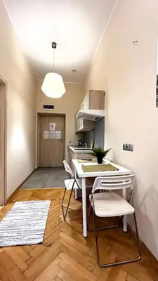 a kitchen with a table and chairs in a room at Studio in City Center in Kraków