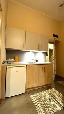a kitchen with a white refrigerator and a dishwasher at Studio in City Center in Kraków
