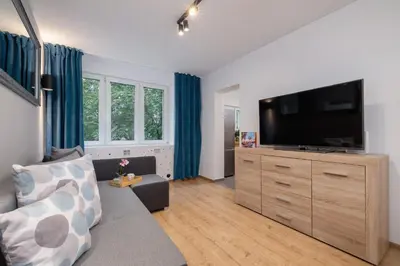 a living room with a couch and a flat screen tv at Jasny Apartament blisko TAURON Arena Kraków by Noclegi Renters in Kraków