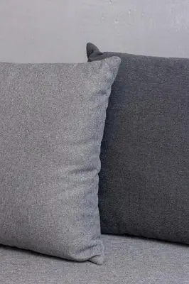 a gray pillow sitting on top of a couch at Jasny Apartament blisko TAURON Arena Kraków by Noclegi Renters in Kraków