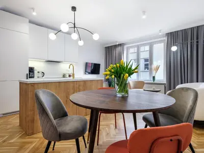 a kitchen and dining room with a table and chairs at Starowiślna by Tyzenhauz in Kraków