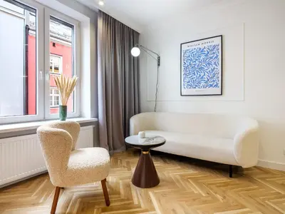 a living room with a white couch and a chair at Starowiślna by Tyzenhauz in Kraków