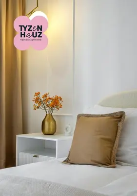 a bed with a pillow and a vase of flowers at Starowiślna by Tyzenhauz in Kraków