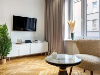 a living room with a tv and a chair and a table at Starowiślna by Tyzenhauz in Kraków