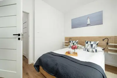 a bedroom with a bed with a lighthouse on the wall at Stylish Apartment near the Bonarka Shopping Center in Cracow by Noclegi Renters in Kraków