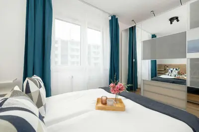 a bedroom with a bed with a vase of flowers on it at Stylish Apartment near the Bonarka Shopping Center in Cracow by Noclegi Renters in Kraków