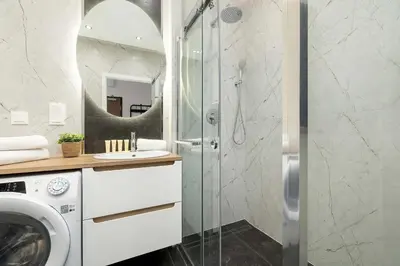a bathroom with a washing machine and a shower at Stylish Apartment near the Bonarka Shopping Center in Cracow by Noclegi Renters in Kraków