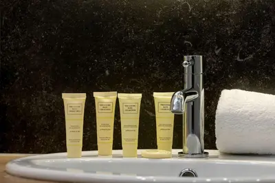 a group of four yellow cups next to a sink at Stylish Apartment near the Bonarka Shopping Center in Cracow by Noclegi Renters in Kraków