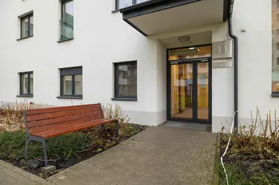 a wooden bench in front of a building at Stylish Apartment near the Bonarka Shopping Center in Cracow by Noclegi Renters in Kraków