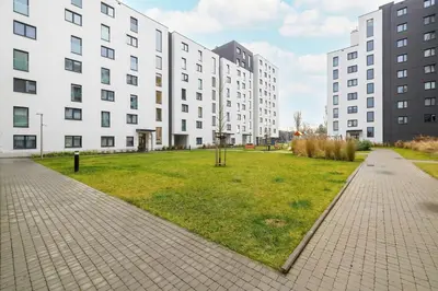a grassy area in front of a large white building at Stylish Apartment near the Bonarka Shopping Center in Cracow by Noclegi Renters in Kraków
