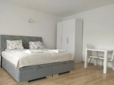 a bedroom with a bed and a window and a chair at Apartament przy 29 alei in Kraków