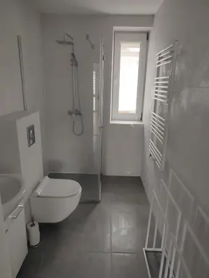 a bed in a white room with a table and a bed at Apartament przy 29 alei in Kraków