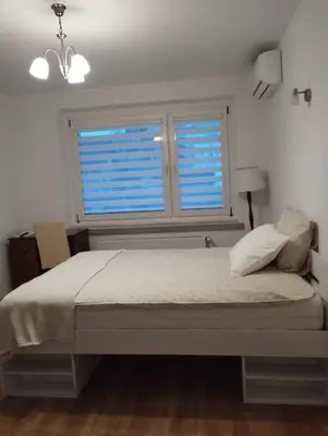a bedroom with two beds and a chair and a television at Apartament przy 29 alei in Kraków