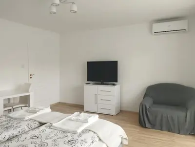a bedroom with a white bed and a television at Apartament przy 29 alei in Kraków